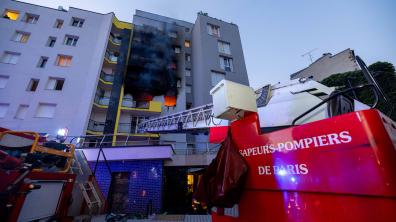 Scène globale de l'intervention, fumée et flammes visibles sur la façade du bâtiment. 